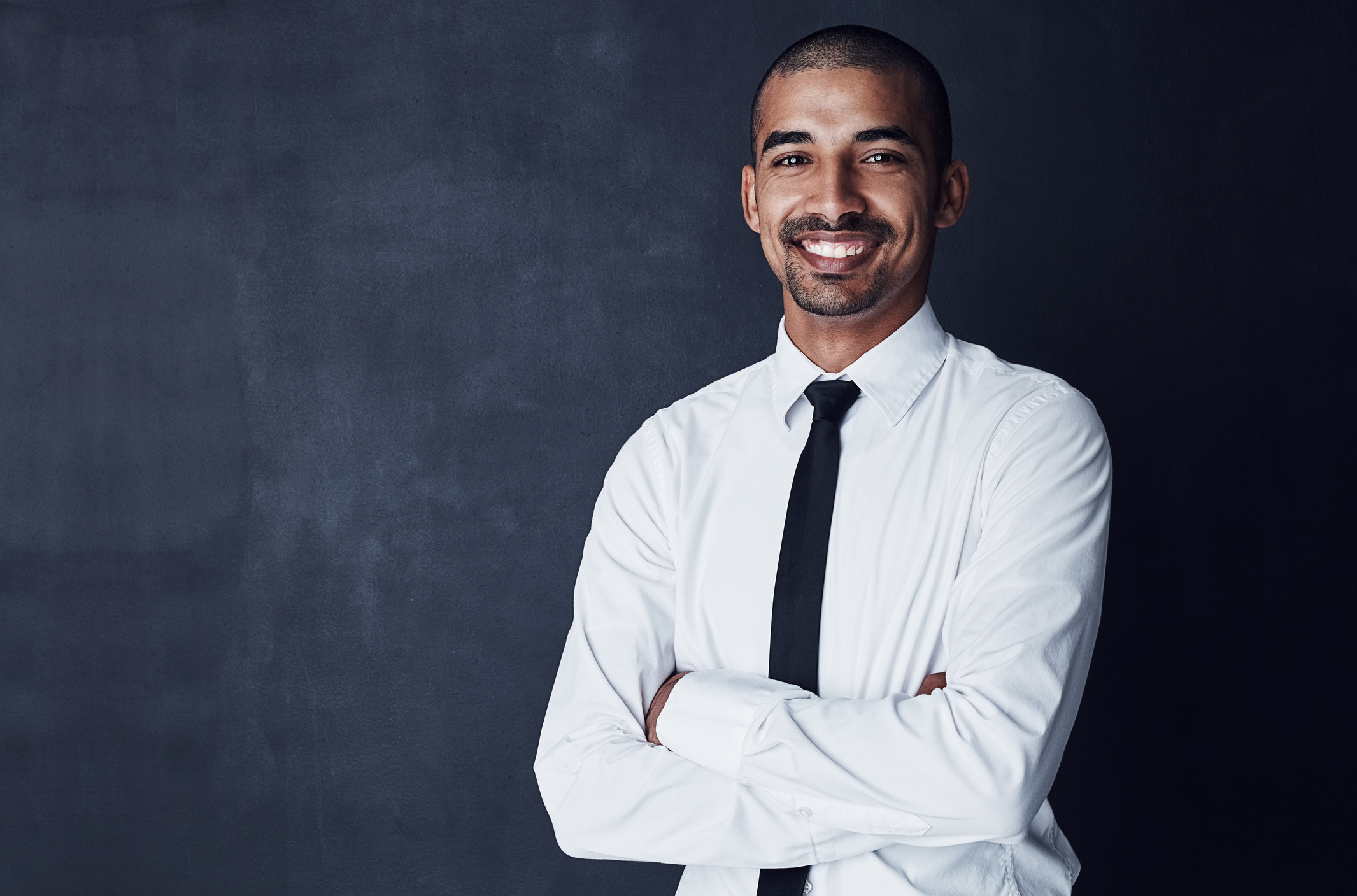 Studio portrait of a confident young businessman against a dark background